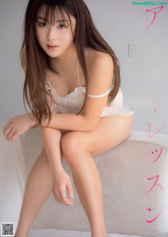 A woman sitting on top of a white couch.