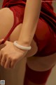 A close up of a woman wearing a red lingerie and a white bracelet.