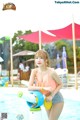 A woman in a bathing suit standing next to a water park.