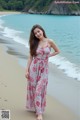 A woman standing on a beach next to the ocean.