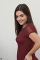 A woman in a maroon dress posing for a picture.