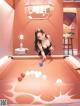 A woman is playing pool in a room.