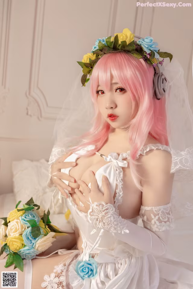 A woman in a wedding dress with pink hair and a flower crown.